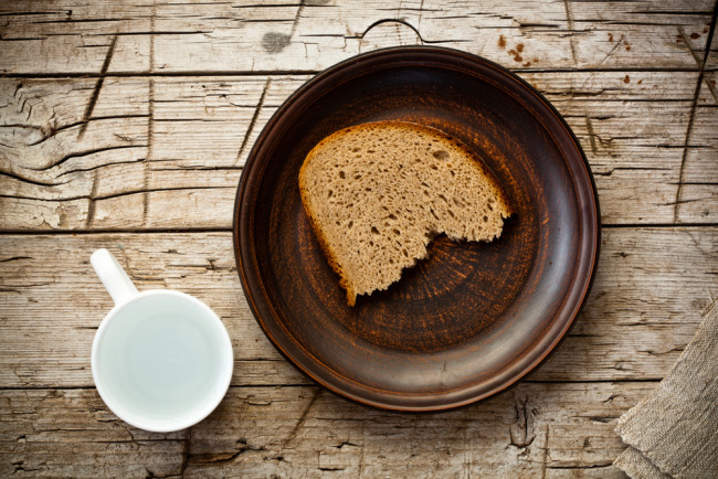 bread and water on rustic wooden background