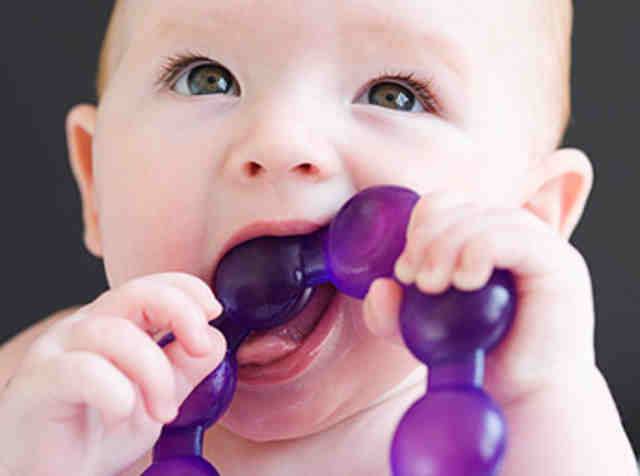 Close up of baby gnawing on teething ring