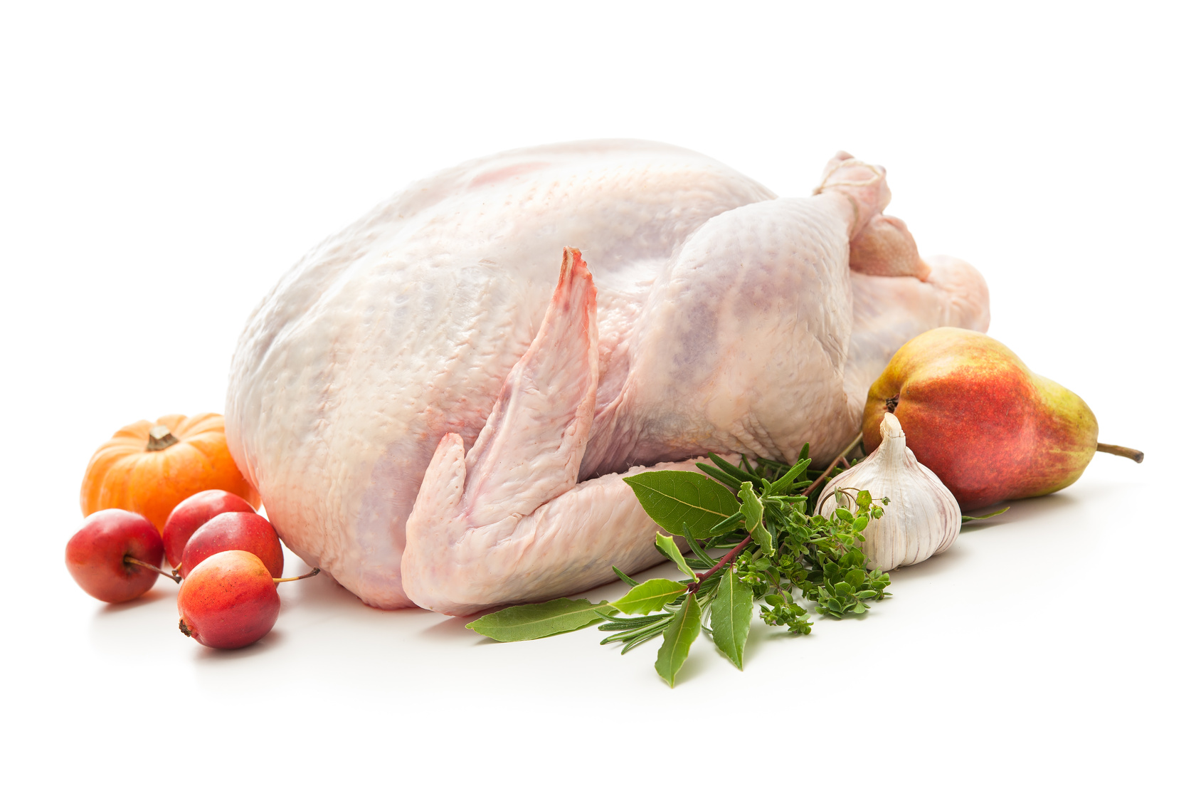 Uncooked turkey with herbs isolated on white background
