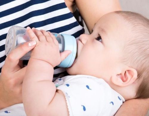 Младенец пьет из бутылочки