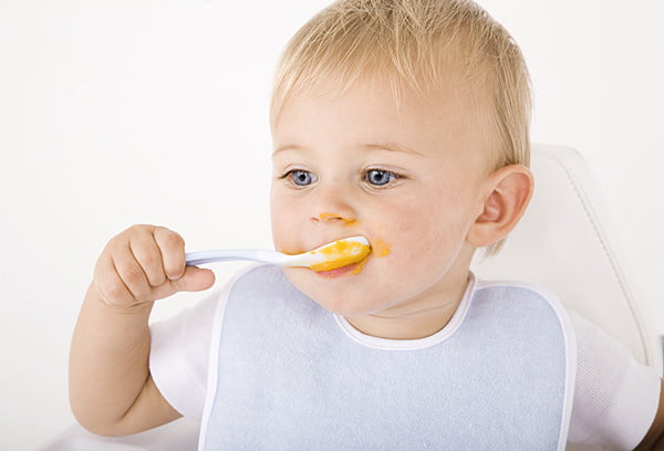 Ребенок кушает кукурузную кашу