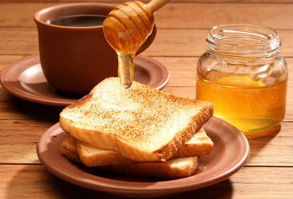 куски хлеба на тарелке и чай с медом