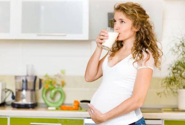 Беременная женщина пьет кефир