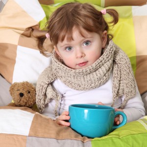 Little girl sitting sick in bed
