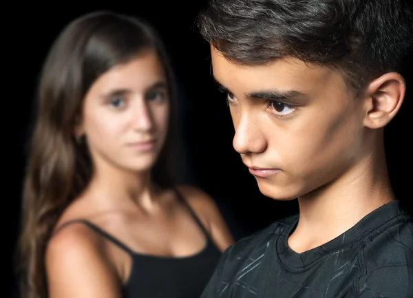 Несчастная молодая пара подростков на черном фоне — стоковое фото