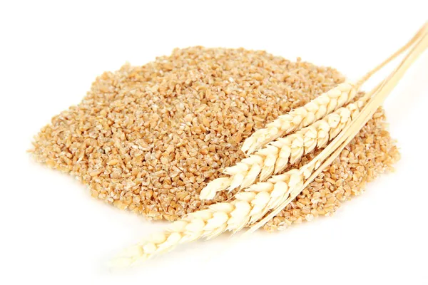 Отруби пшеницы с деревянной ложкой, изолированной на белом — стоковое фото