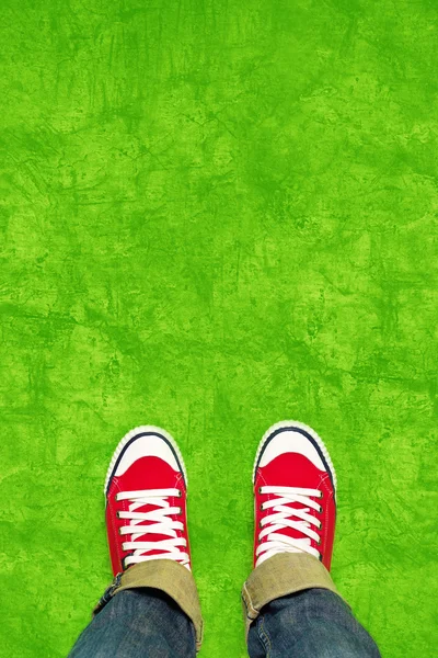 Ноги сверху, подросток в кроссовки, стоя на зеленый му — стоковое фото