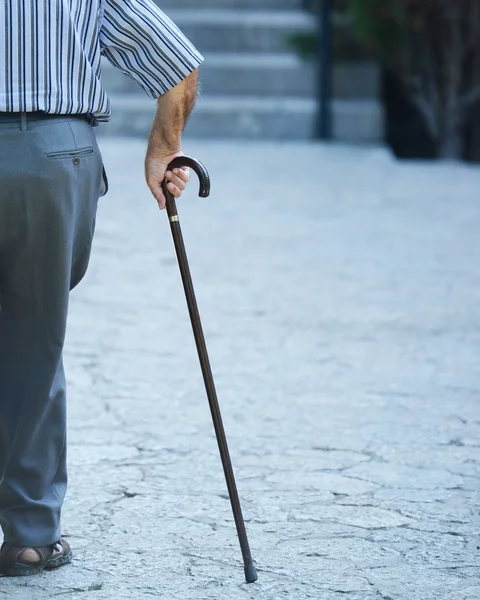 Старик ходить своими руками на деревянной тростью — стоковое фото