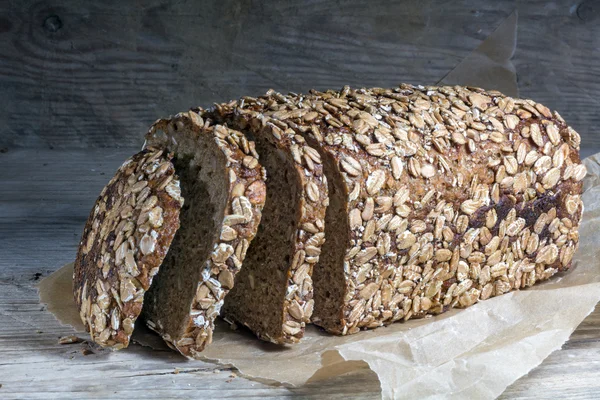 Темный хлеб хлеб с цельного зерна и семян на старый деревянный кабана — стоковое фото
