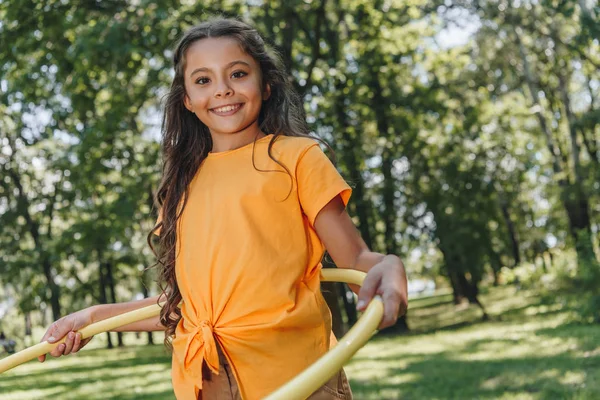 Adorable Happy Child Playing Hula Hoop Smiling Camera Park — стоковое фото